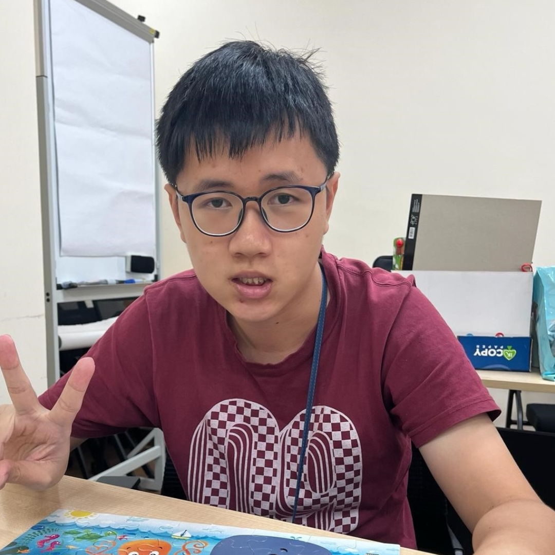 Lucas posing with a completed puzzle on the table